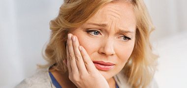 Woman holding jaw in pain