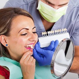 A woman trying porcelain veneers with her dentist’s help
