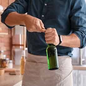 Man uses bottle opener to open bottle