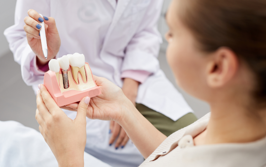 Dentist showing patient dental implant model
