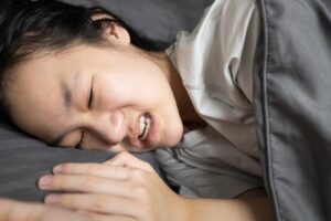 woman trying to sleep with bruxism