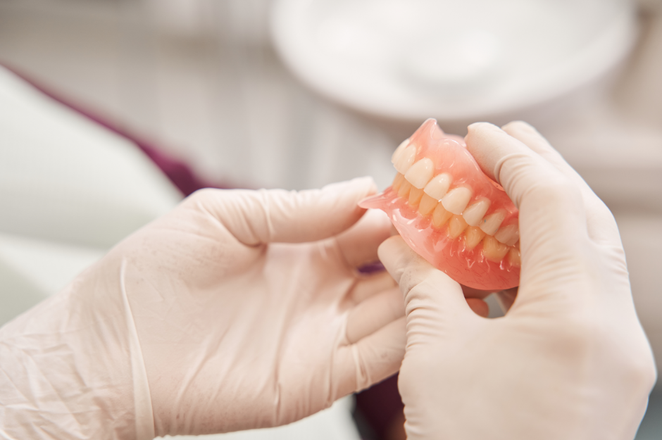 Dentist holding dentures
