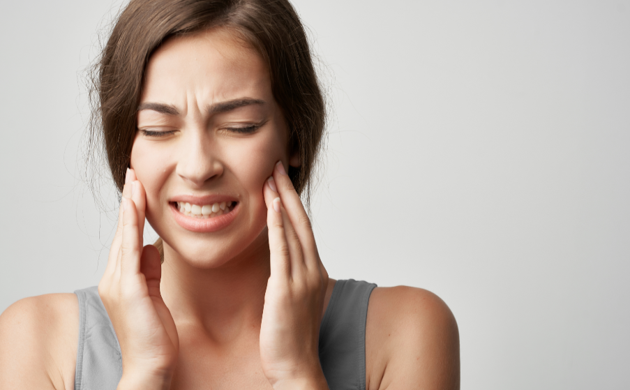 Woman holding jaw in pain